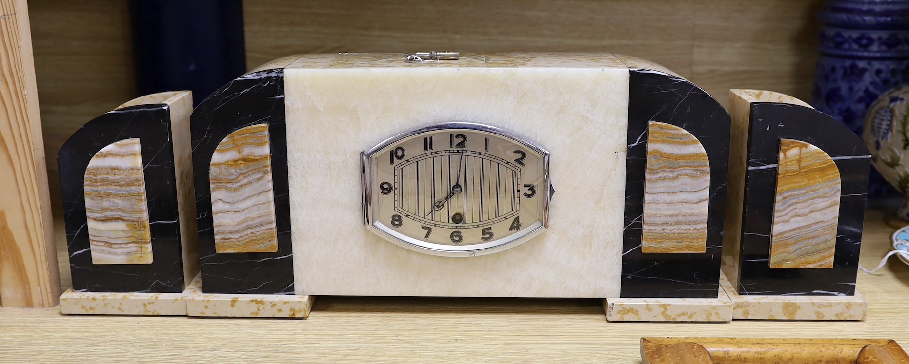 An Art Deco onyx and marble clock garniture, The clock 43 cm wide